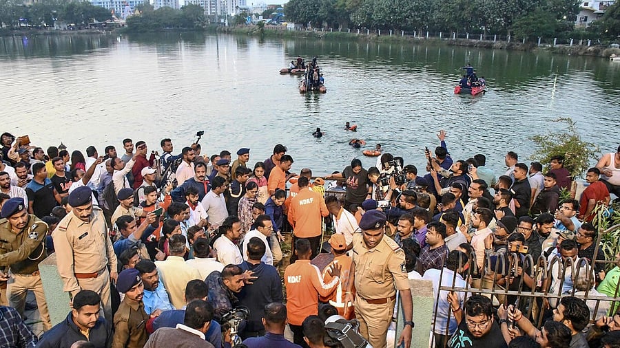 <div class="paragraphs"><p>People gather during a rescue and search operation after a boat overturned in a lake, in Vadodara.</p></div>