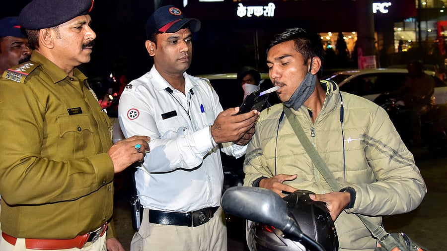 <div class="paragraphs"><p>A policemen takes alcohol breath test of a motorist to tackle drunk driving.</p></div>