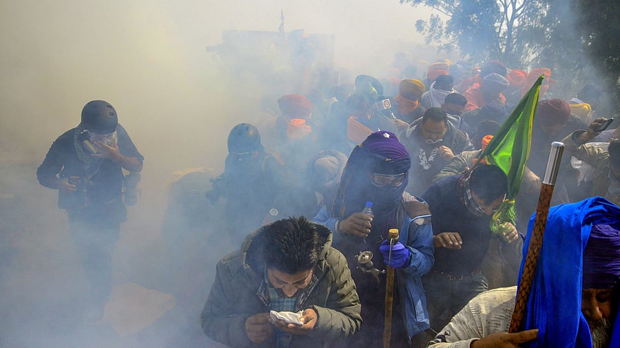 <div class="paragraphs"><p>Farmers look for cover after police fired tear gas at them during their 'Dilli Chalo' march, near the Punjab-Haryana Shambhu border, in Patiala district, on Wednesday</p></div>