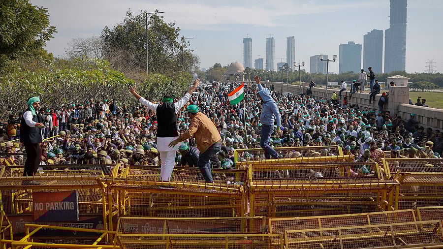 <div class="paragraphs"><p>Farmers climb a police barricade during a protest demanding a hike in land compensation and better rehabilitation facilities for their families, in Noida on the outskirts of New Delhi, February 8.</p></div>