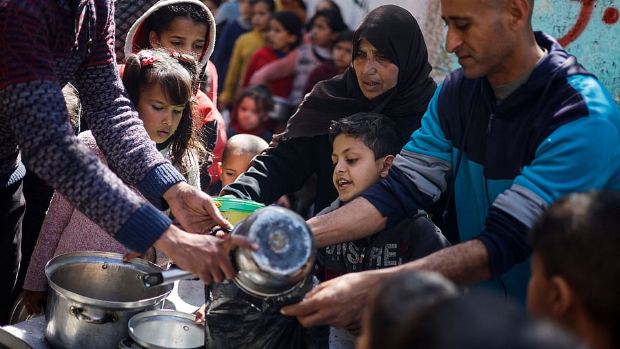 <div class="paragraphs"><p>Palestinian children wait to receive food cooked by a charity kitchen amid shortages of food supplies, in Rafah.</p></div>