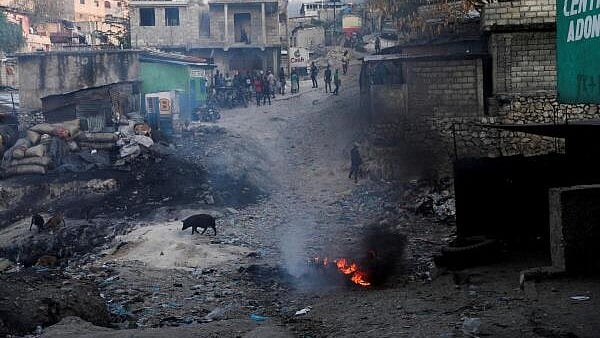 <div class="paragraphs"><p>People gather as they watch from afar after an alleged gang member was killed and set on fire.</p></div>