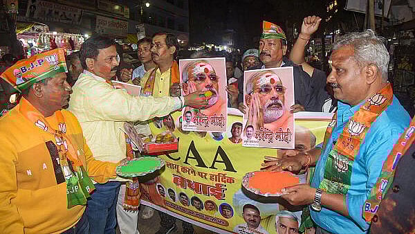 <div class="paragraphs"><p>BJP workers celebrate after the central government notified the rules for implementation of the Citizenship (Amendment) Act, 2019, in Varanasi, Monday, March 11, 2024. </p></div>