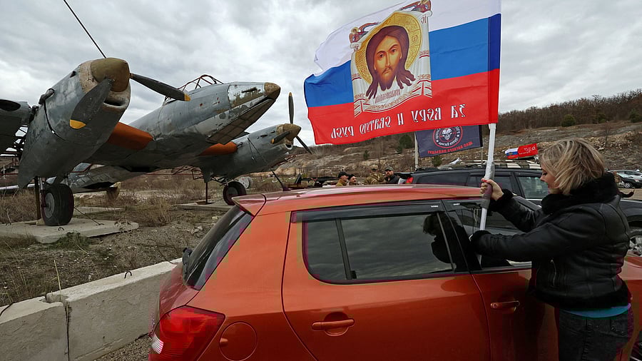 <div class="paragraphs"><p>A woman attaches a flag to a car before an automobile rally to mark Defender of the Fatherland Day and in support of Russian service members fighting in Russia-Ukraine conflict.</p></div>