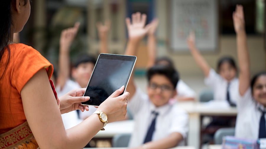 Teacher using tablet computer in elementary school lesson