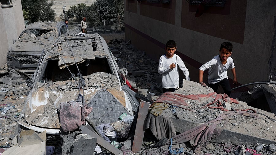<div class="paragraphs"><p>Children stand near a damaged vehicle at the site of an Israeli strike on a house, amid the ongoing conflict between Israel and Hamas.</p></div>