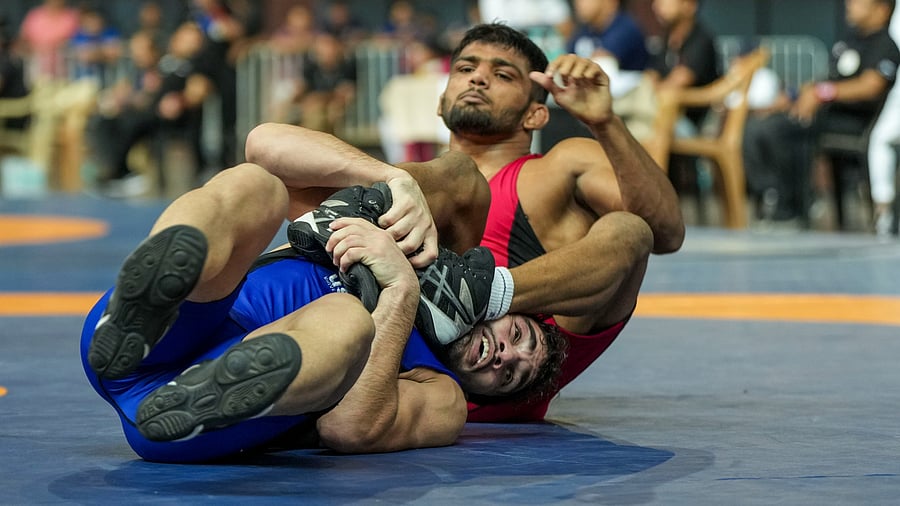 <div class="paragraphs"><p>A file photo of Atish Todkar of Maharashtra (in red) and Rahul of Delhi compete in the men's freestyle 57 kg category event during the Asian Games 2023 wrestling trials, at IG Stadium in New Delhi.</p></div>