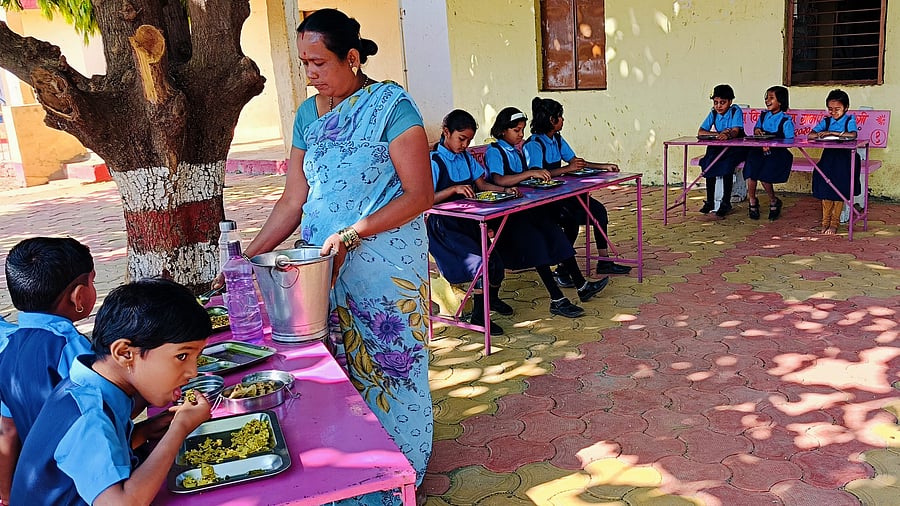 <div class="paragraphs"><p>An employee serves mid-day meal to students at a school. (Representative image)</p></div>