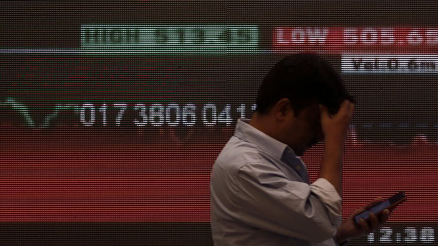 <div class="paragraphs"><p>File Photo: A man stands in front of a screen displaying news of market updates inside the Bombay Stock Exchange (BSE) building in Mumbai.</p></div>