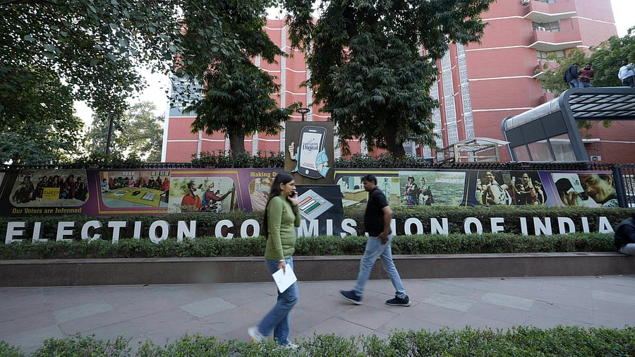<div class="paragraphs"><p>People walk past the Election Commission of India premises, in New Delhi</p></div>