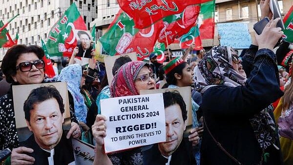 <div class="paragraphs"><p>Supporters of former Prime Minister Imran Khan's party, the Pakistan Tehreek-e-Insaf (PTI), carry posters and placards</p></div>