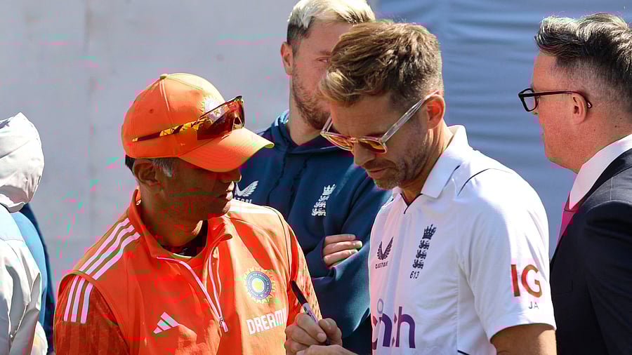 <div class="paragraphs"><p>England's James Anderson signs his autograph on a ball for India coach Rahul Dravid after the match.</p></div>