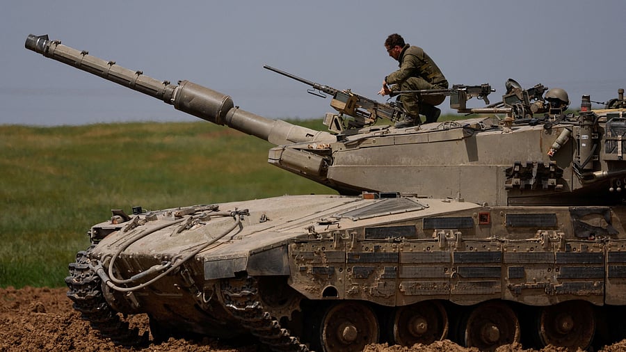 <div class="paragraphs"><p>An Israeli soldier unloads a weapon on top of a tank.</p></div>