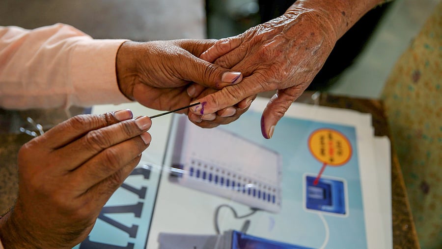 <div class="paragraphs"><p>A voter gets her finger marked with indelible ink.</p></div>
