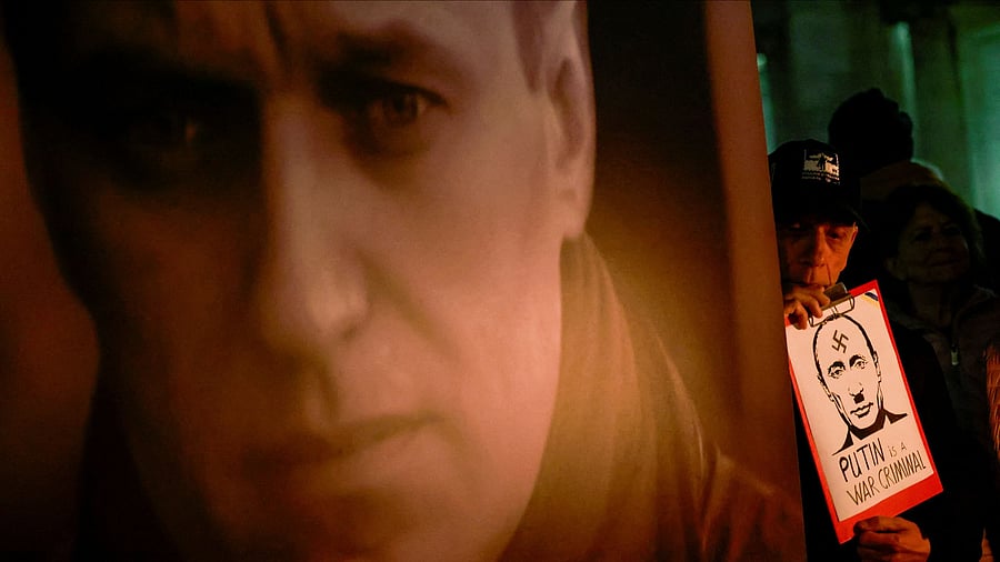 <div class="paragraphs"><p>File Photo: A man holds a placard depicting Russian President Vladimir Putin, during a vigil in memory of late Russian opposition leader Alexei Navalny,in Rome, Italy, February 19, 2024. REUTERS/Yara Nardi/File Photo</p></div>