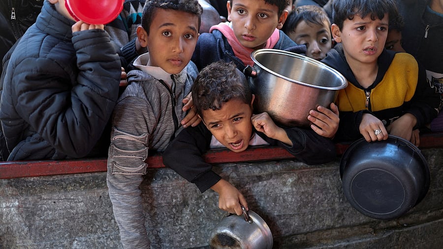 <div class="paragraphs"><p>File Photo: Palestinian children wait to receive food cooked by a charity kitchen amid shortages of food supplies, as the ongoing war between Israel and the Palestinian Islamist group Hamas continues, in Rafah, in the southern Gaza Strip, February 5, 2024. </p></div>