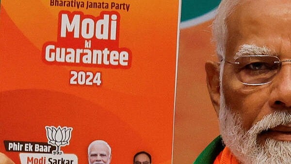 <div class="paragraphs"><p>Prime Minister Narendra Modi displays a copy of BJP's election manifesto for the general election, in New Delhi, India, April 14, 2024.</p></div>