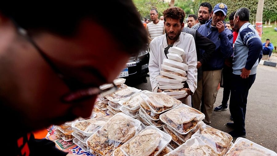 <div class="paragraphs"><p>A volunteer distributes hot meals for the fasting public during the holy month of Ramadan amid the economic crisis in Cairo.</p></div>