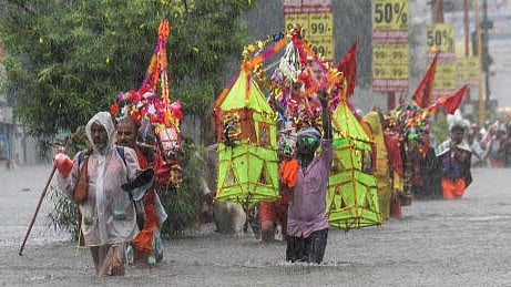 <div class="paragraphs"><p>Lord Shiva devotees or 'Kanwariyas' carrying holy water from the Ganga river wade through a waterlogged road amid monsoon rainfall during their pilgrimage in the month of 'Shravan', in Haridwar</p></div>