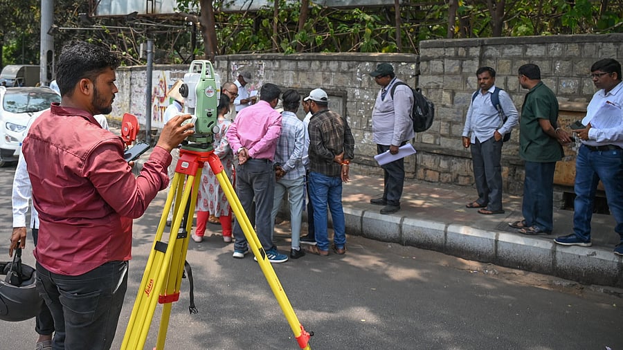 <div class="paragraphs"><p>BBMP workers undertake a land survey near Mekhri Circle on Friday. </p></div>