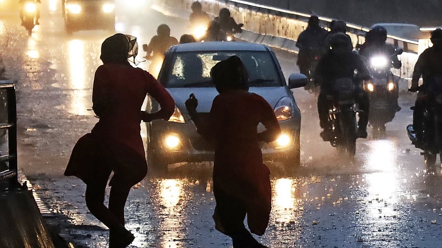 <div class="paragraphs"><p>People caught in the rain in Bengaluru. Representative image.</p></div>
