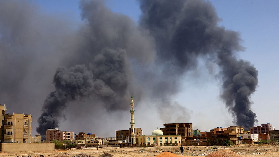 <div class="paragraphs"><p>A man walks while smoke rises above buildings in Khartoum North, Sudan.</p></div>