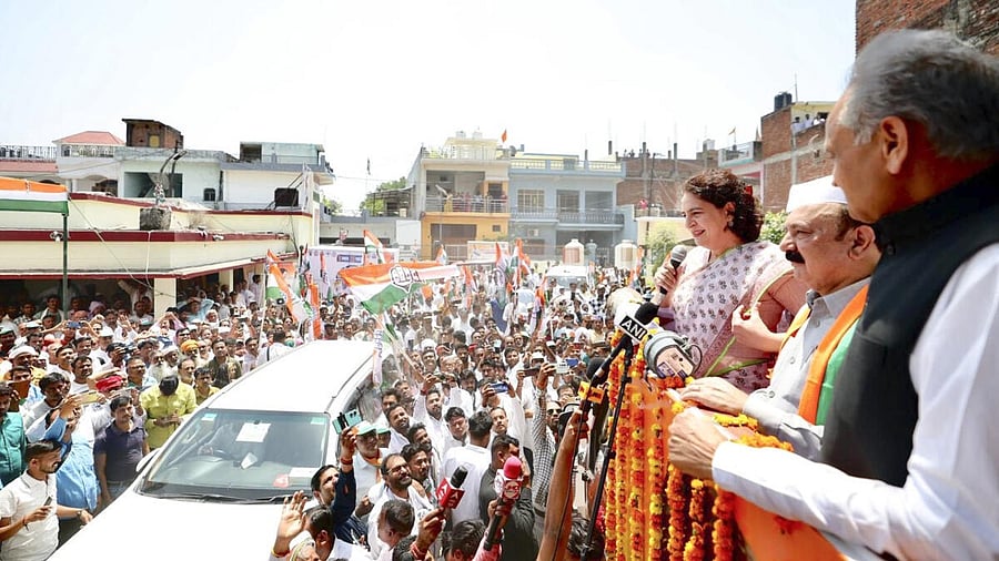 <div class="paragraphs"><p>Congress leader Priyanka Gandhi Vadra with former Rajasthan chief minister Ashok Gehlot addresses supporters during a roadshow before the nomination filing of the party candidate from Amethi constituency Kishori Lal Sharma (C), ahead of the third phase of Lok Sabha elections, in Amethi district, Friday, May 3, 2024.</p></div>