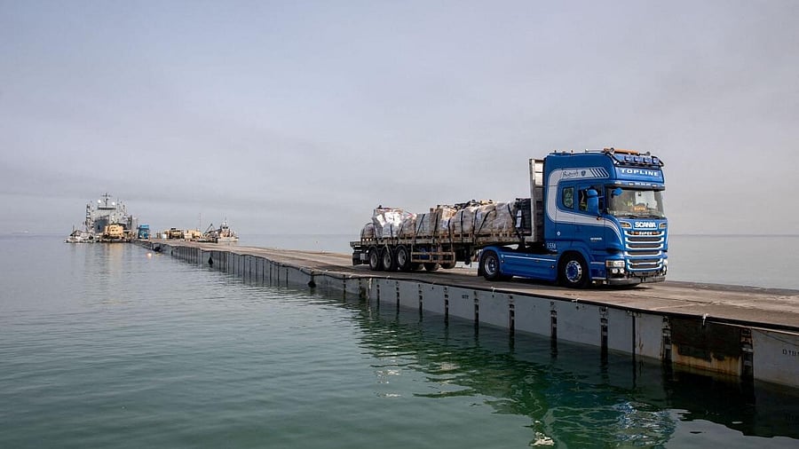 <div class="paragraphs"><p>Trucks deliver humanitarian aid over a temporary pier on the Gaza coast</p></div>