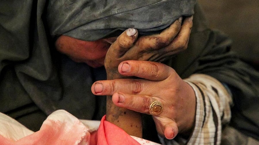 <div class="paragraphs"><p>Palestinian woman Buthayna Abu Jazar reacts as she holds the hand of her son Hazma, who was killed in an Israeli strike, amid the ongoing conflict between Israel and Hamas, in Rafah, in the southern Gaza Strip.</p></div>
