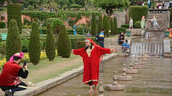 <div class="paragraphs"><p> Tourists click photos during their visit to Nishat Bagh Mughal garden, on the banks of Dal Lake in Srinagar.</p></div>