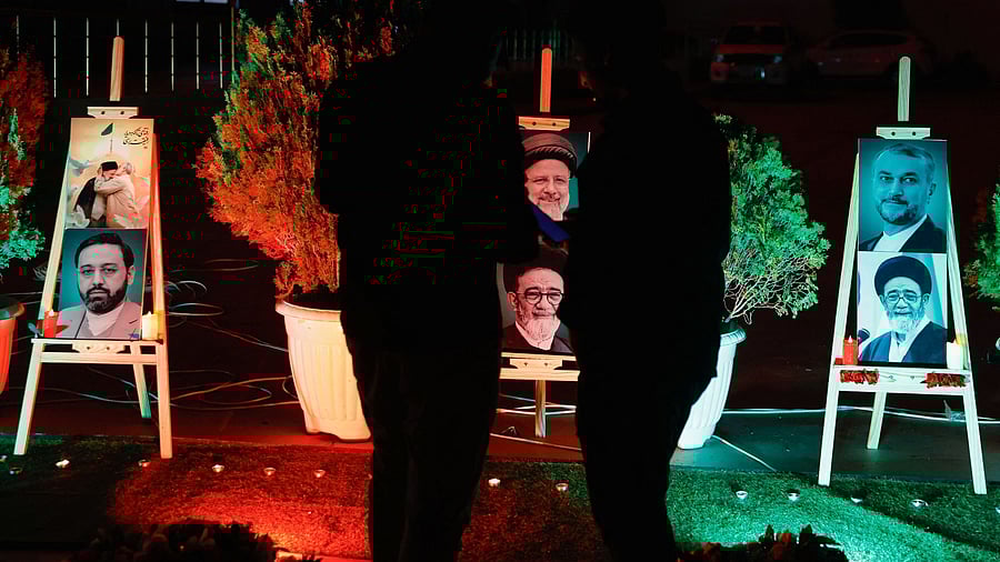 <div class="paragraphs"><p>Men stand as they offer condolences over the deaths of Iran's President Ebrahim Raisi and others.</p></div>