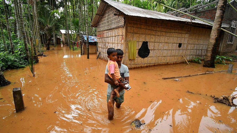 <div class="paragraphs"><p> A man carries a child in a flooded village after heavy rains following the landfall of Cyclone Remal at Singi Mari near Kampur in Nagaon district of Assam. </p></div>