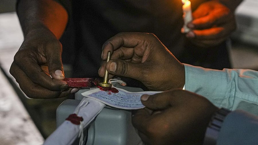 <div class="paragraphs"><p>Polling officials seal the Electronic Voting Machine (EVM) at the end of voting during the third phase of Lok Sabha elections, at a polling station, in Hathras, Uttar Pradesh.</p></div>