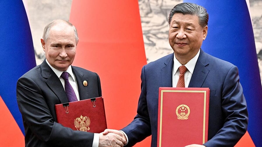 <div class="paragraphs"><p>Russian President Vladimir Putin (left) and his Chinese counterpart Xi Jinping exchange bilateral documents during a meeting in Beijing. </p></div>