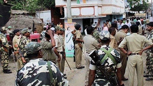 <div class="paragraphs"><p>Security personnel stand in front of a polling booth after an incident of violence during polls. </p></div>