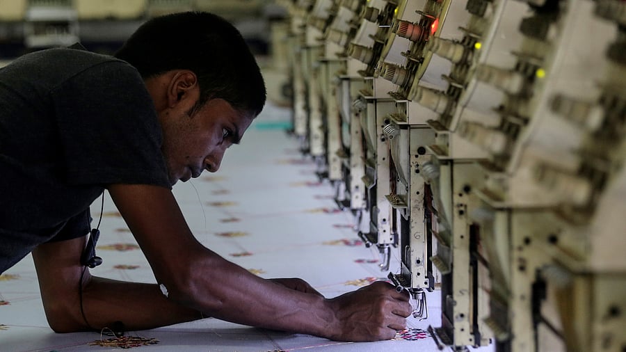 <div class="paragraphs"><p>A worker adjusts the thread on an embroidery machine at a workshop in Mumbai.(Representative image)</p></div>