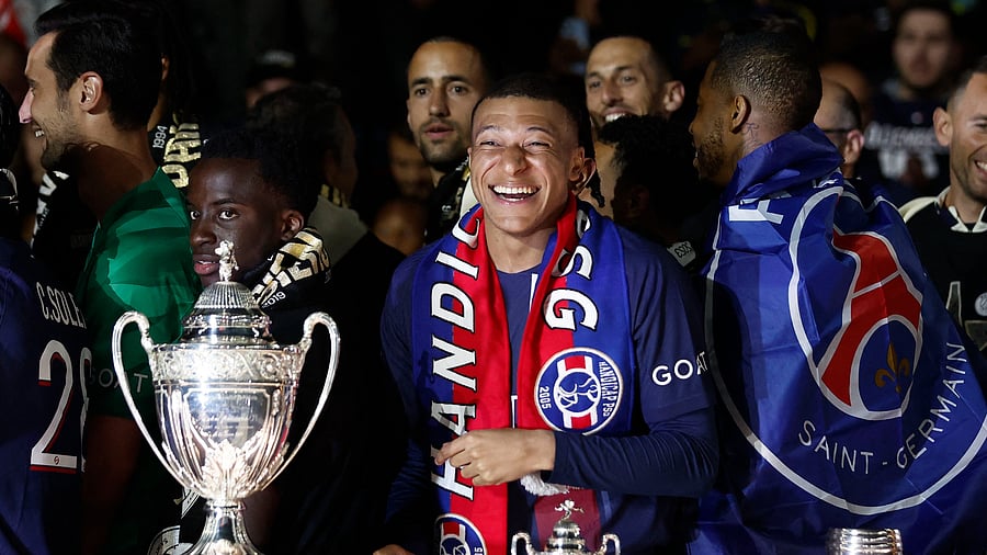 <div class="paragraphs"><p>Paris St Germain's Kylian Mbappe poses with some of the trophies he won with Paris St Germain after his last match with the team and winning the Ligue 1</p></div>