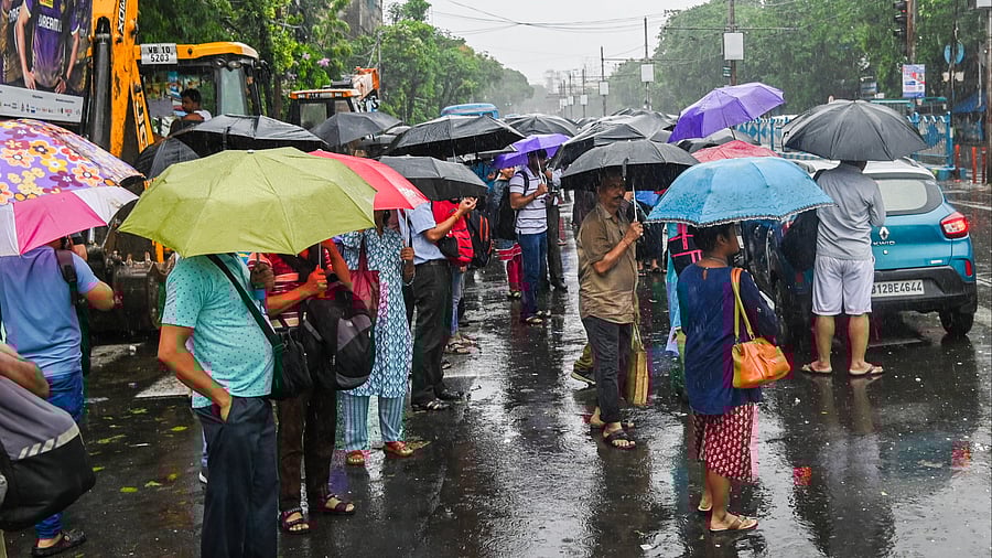 <div class="paragraphs"><p>Commuters wait for buses at a stop during rain in the aftermath of Cyclone Remal's landfall, in Kolkata, Monday.</p></div>