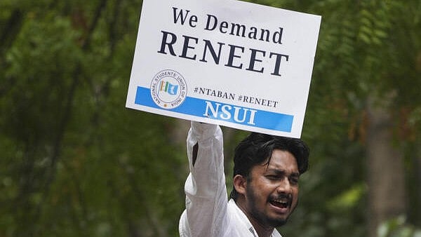 <div class="paragraphs"><p>An NSUI activist holds a placard during ‘Chhattra Sansad Gherav’ protest at Jantar Mantar against the alleged irregularities in NEET-UG and cancellation of UGC-NET exams, in New Delhi. Image for representation only.</p></div>