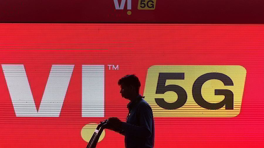 <div class="paragraphs"><p>A man walks across the LED display board showing the logo of Vodafone-Idea.</p></div>