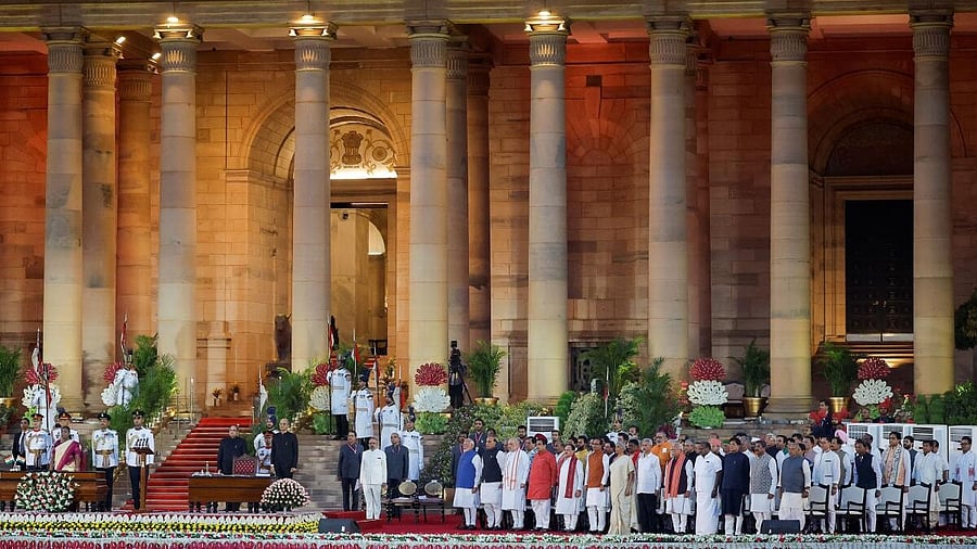 <div class="paragraphs"><p>Droupadi Murmu, Prime Minister Narendra Modi and ministers stand for the national anthem, during the swearing-in ceremony at the presidential palace in New Delhi.&nbsp;</p></div>