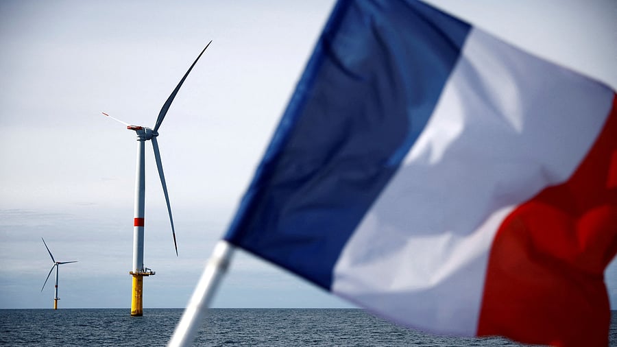 <div class="paragraphs"><p>A French flag flies in front of wind turbines at the Saint-Nazaire offshore wind farm, off the coast of the Guerande peninsula in western France. </p></div>