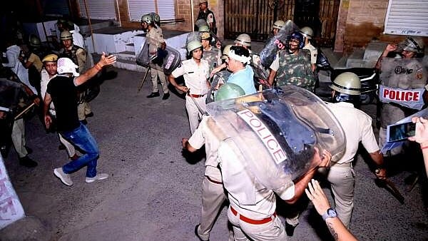 <div class="paragraphs"><p>Police personnel detain a person after stone pelting took place during a clash between two groups, in Jodhpur. </p></div>
