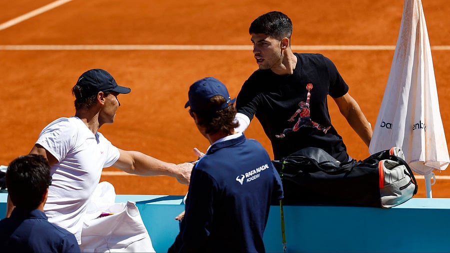 <div class="paragraphs"><p>Carlos Alcaraz shakes hands with compatriot Rafael Nadal during a&nbsp; practice session.</p></div>