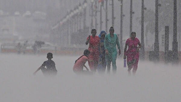 <div class="paragraphs"><p>Visitors caught in the rain, at Kartavya Path in New Delhi on June 21.</p></div>