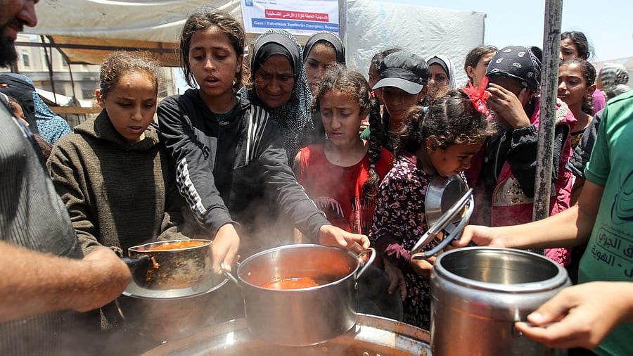 <div class="paragraphs"><p>Palestinians gather to receive food cooked by a charity kitchen, amid shortages of aid supplies, as the conflict between Israel and Hamas continues, in Khan Younis, in the southern Gaza Strip on June 19, 2024. </p></div>
