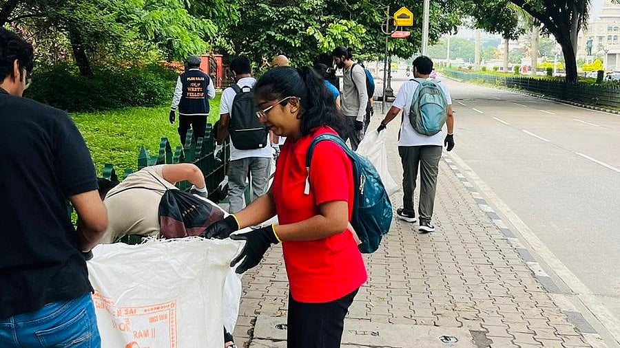 Volunteers of the Indian Ploggers Army clear liquor bottles and paper cups near Vidhana Soudha.
