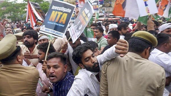 <div class="paragraphs"><p>Police personnel try to stop Congress workers during their protest march over the alleged irregularities in NEET-UG 2024 results, in Varanasi, Saturday, June 22, 2024. </p></div>