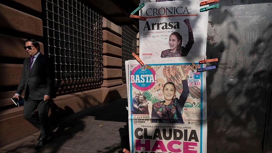 <div class="paragraphs"><p>A man walks past newspapers displaying the victory of the presidential candidate of the ruling Morena party Claudia Sheinbaum, a day after the general election.</p></div>