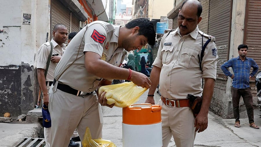 <div class="paragraphs"><p>A police officer pours sugar in a water container to make a sweet drink outside a polling station in New Delhi. </p></div>